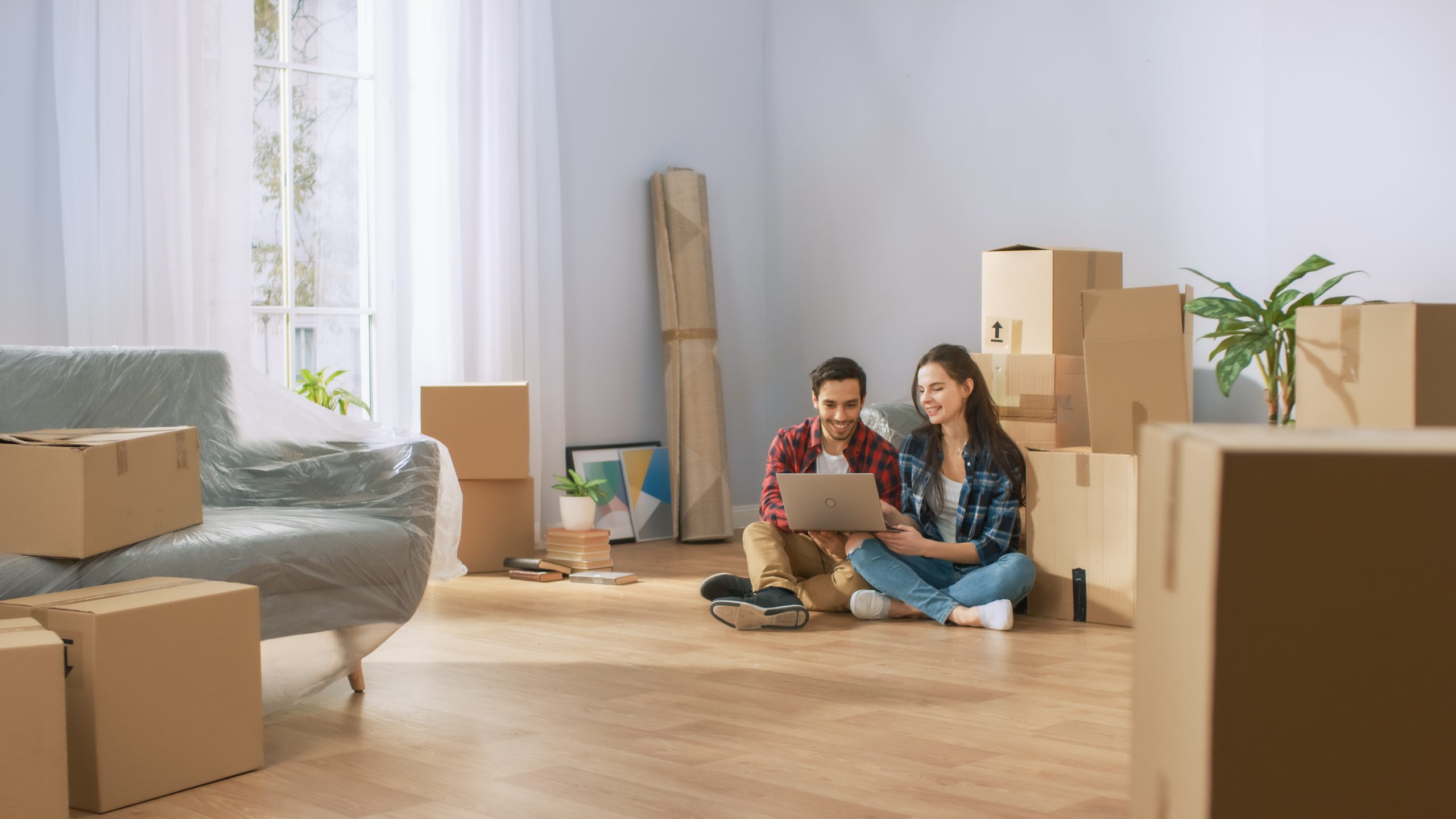 Man and Woman sitting on floor of newly moved in house