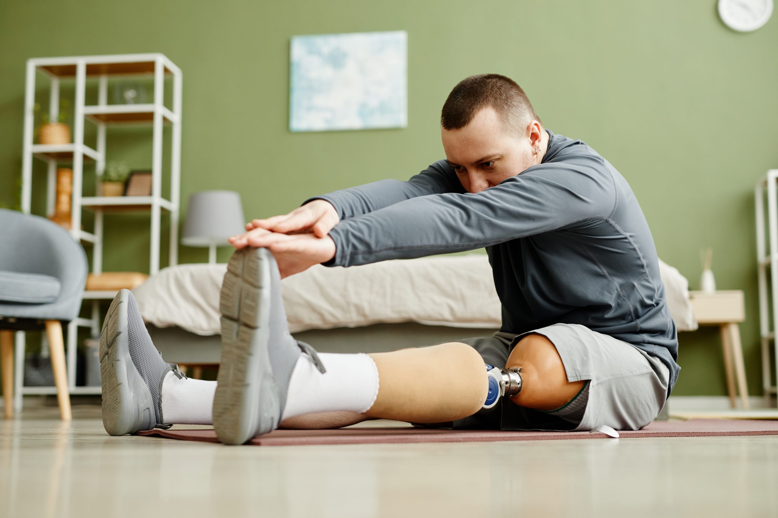 Man with a prosthetic leg, stretching and exercising
