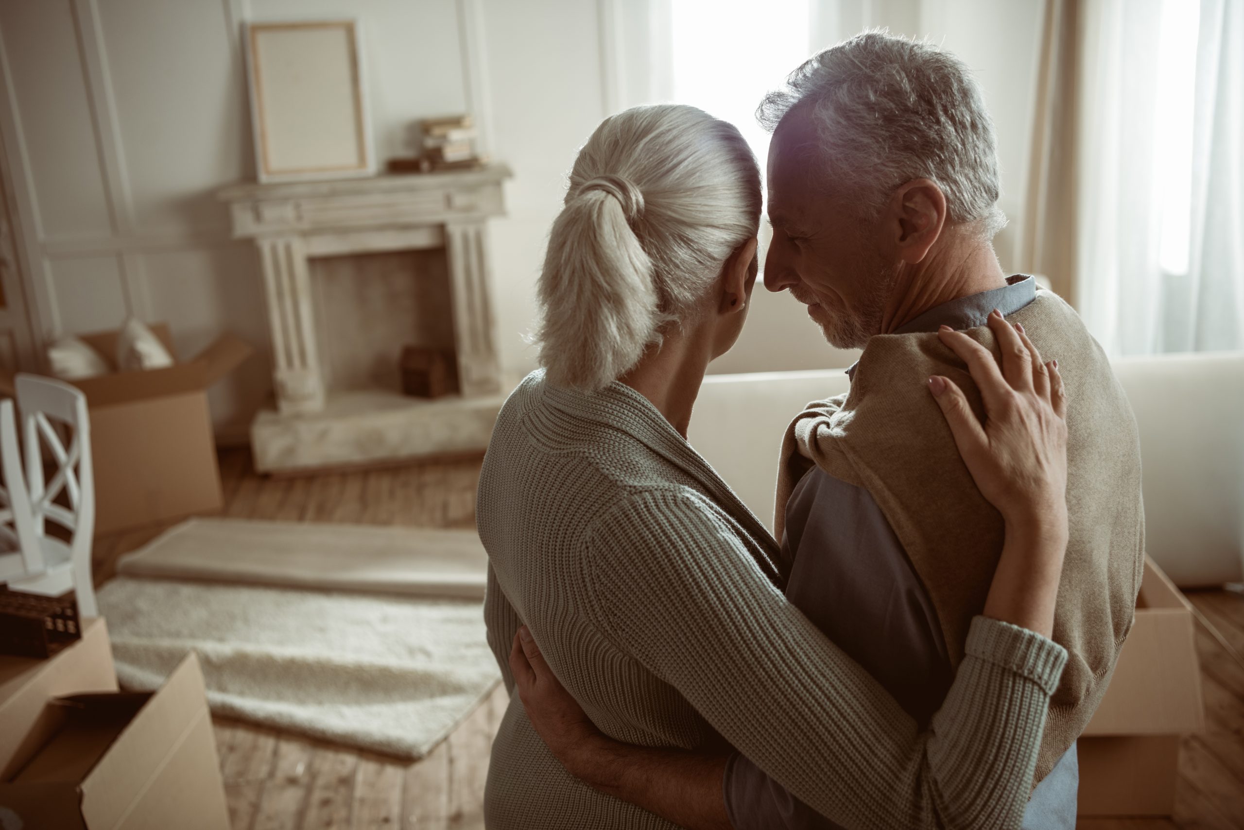 Elderly couple standing in living room