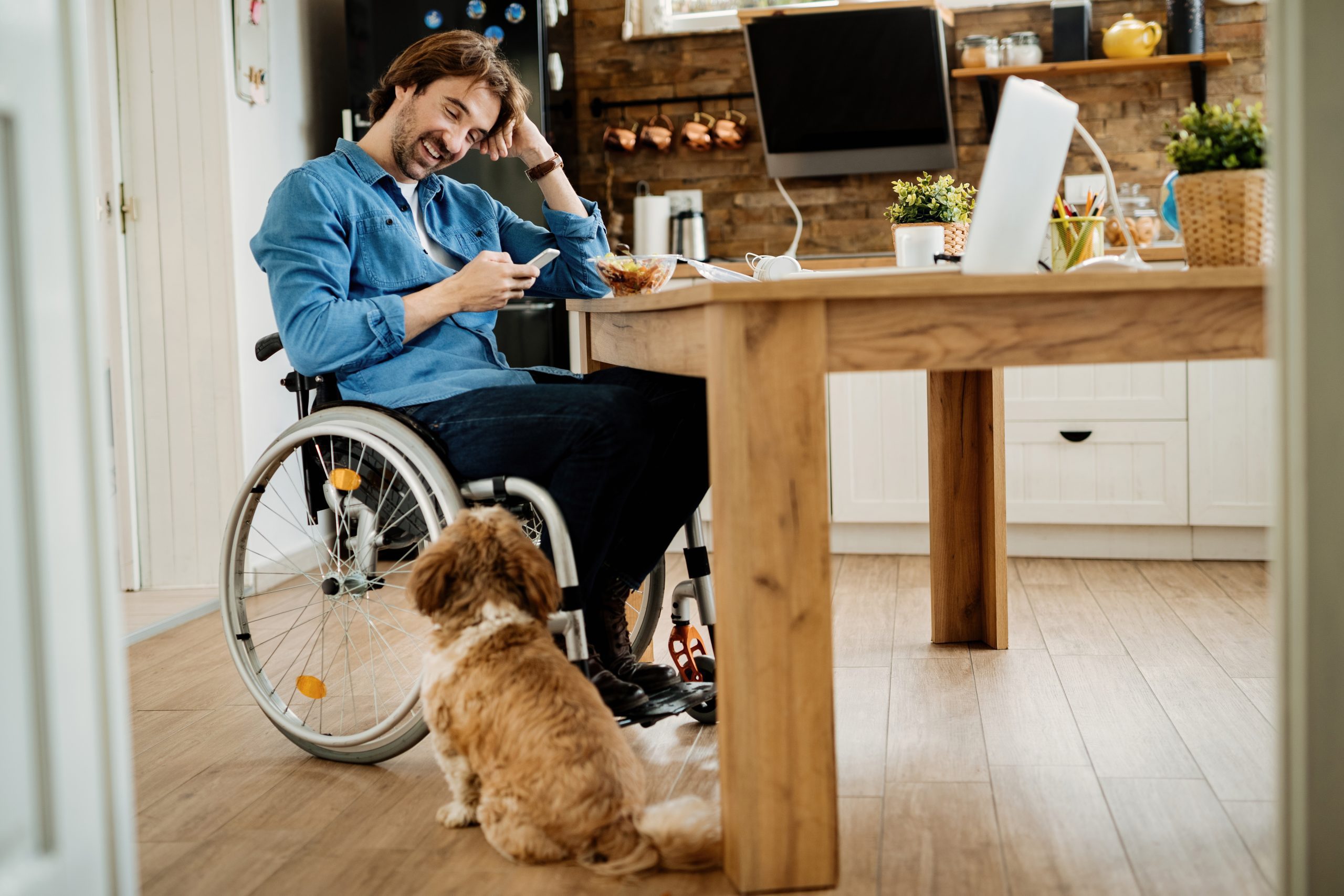 Happy disabled man working from home with his dog