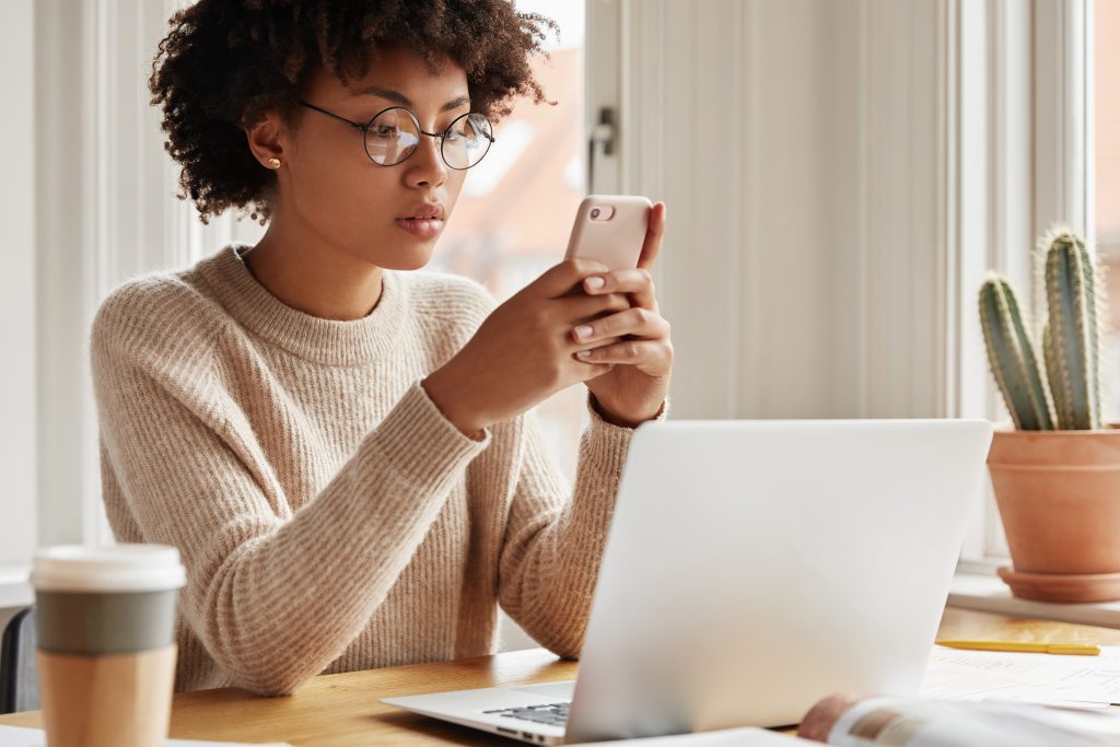 Cropped image of a serious woman holding a smart phone